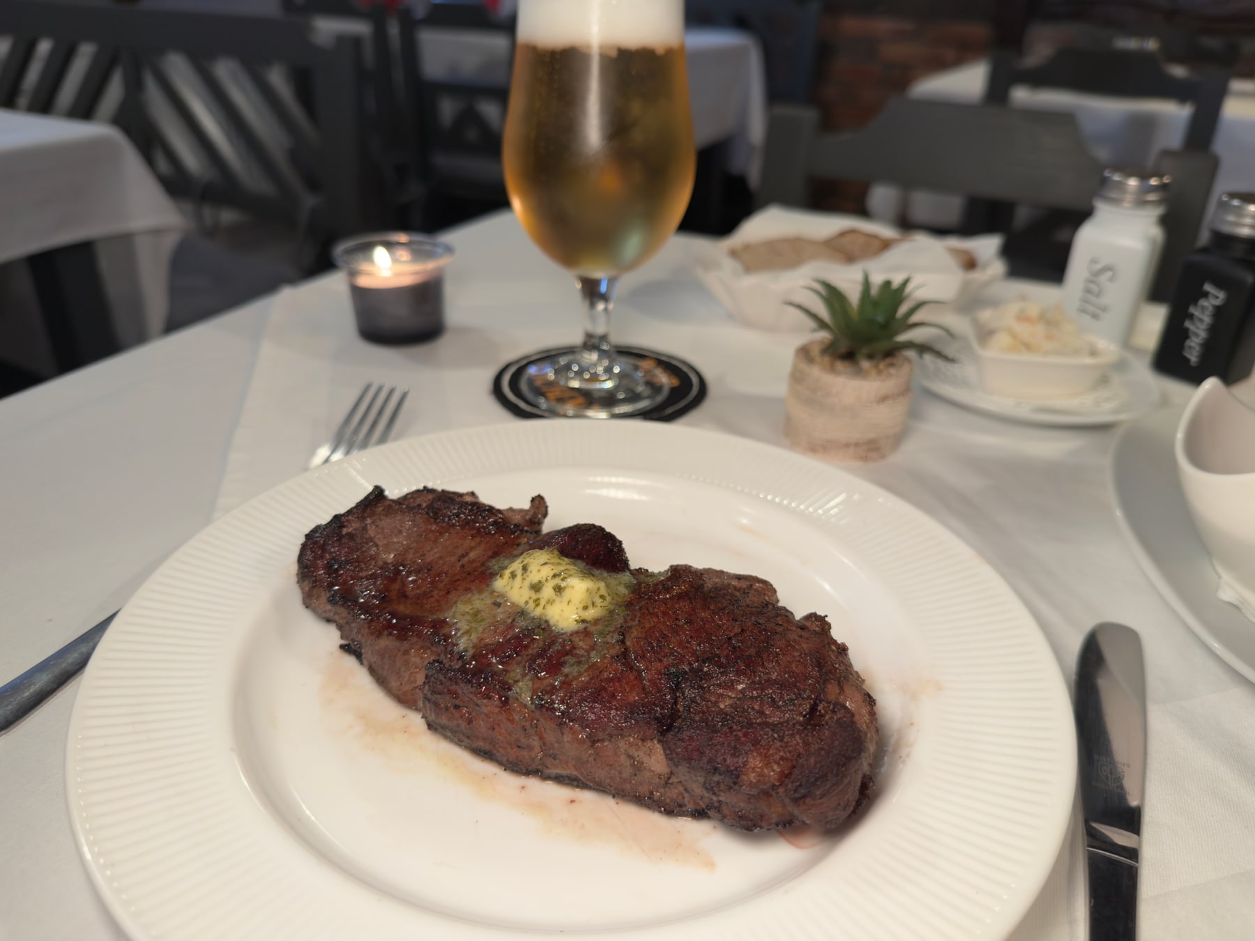 Rumpsteak mit Kräuterbutter auf weißem Teller