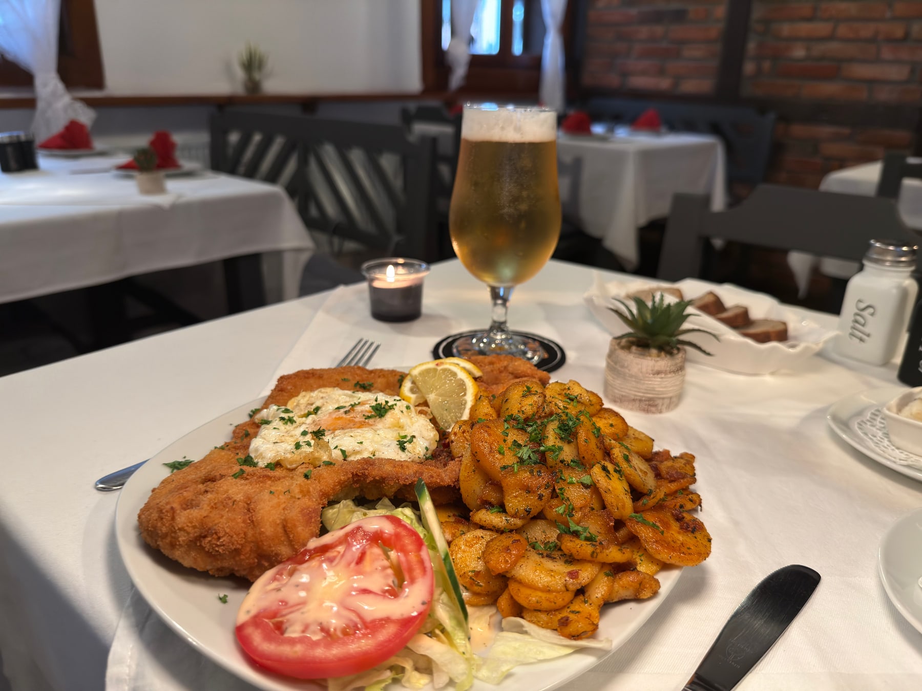 Paniertes Schnitzel mit Spiegelei, Bratkartoffeln und Salat